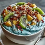 Creamy blue spirulina smoothie bowl, a healthy breakfast bursting with sweet, juicy fruit.