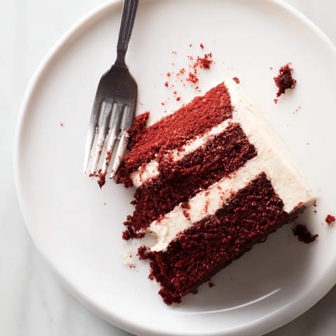 Freshly sliced Red Velvet Cake reveals its deep crimson layers and thick, snowy cream cheese frosting. The moist crumb with cocoa hints is perfect for birthdays and Southern gatherings.