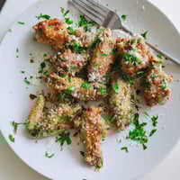 Golden brown Garlic Parmesan Wings fresh from the oven, tossed in a garlic butter sauce and sprinkled with fresh parsley.